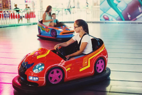 在游乐园的游戏机中驾驶汽车商场的女孩 — 图库照片