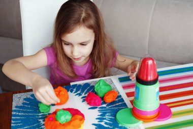 seçici odak masada evde, hamuru ile oynayan kız