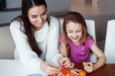 portakal yeme, evde masada oturan kızı annesiyle