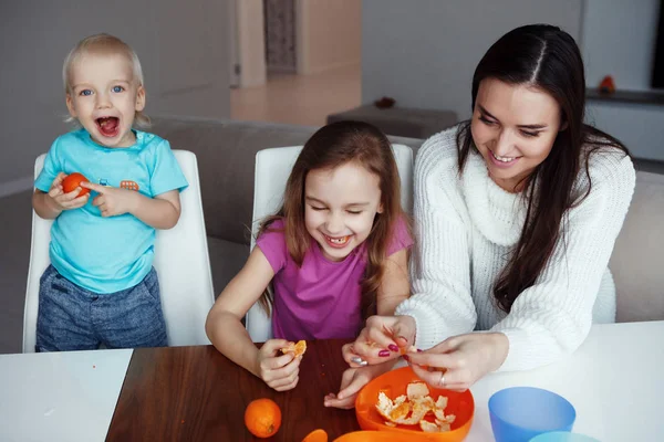 Mãe Com Filho Filha Comendo Laranjas Sentado Mesa Casa — Fotografia de Stock