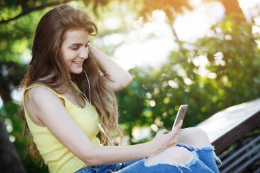 Smartphone vasıl seyir ve gülümseyen genç kadın 