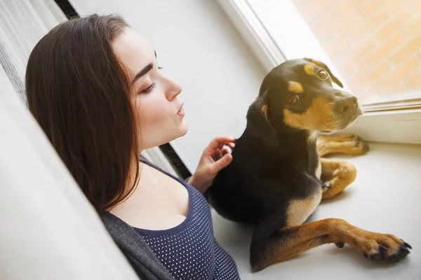 woman and dog looking out window, focus on foreground