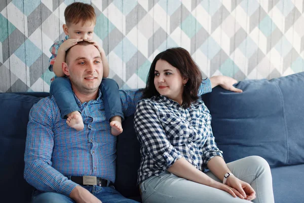 Jovem Família Sentada Sofá Azul Sorrindo — Fotografia de Stock