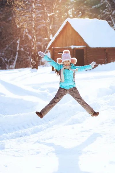 かわいい小さな女の子が遊んで冬公園で雪の上をジャンプ — ストック写真