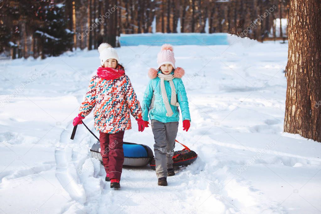 Happy little Girls slidding snow tubing
