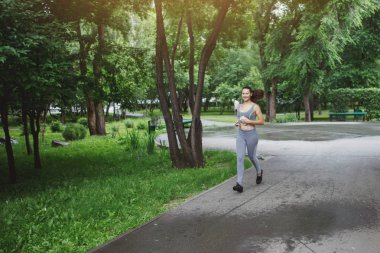 Genç kadın yeşil park yolda koşu