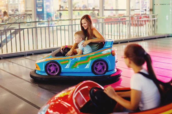 十几岁的女孩和小男孩驾驶汽车街机在游戏机在游乐园 — 图库照片