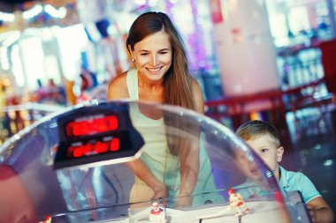 Anne ve çocuk oyun makinesi Masa Hokeyi arcade eğlence parkında oynarken