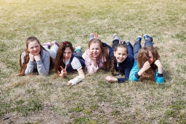 Bir grup çocuk gülümseme, eğlenceli, yeşil çim üzerinde yalan var. Çocuk eğlence, sağlıklı yaşam kavramı.