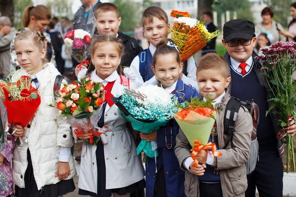 Un grupo de escolares con flores . — Foto de Stock