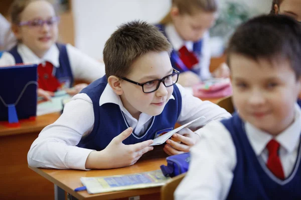 Schüler am Schreibtisch denken und entscheiden die Aufgabe in der Schule. Grundschulbildung, Ausbildung und Personalkonzept — Stockfoto