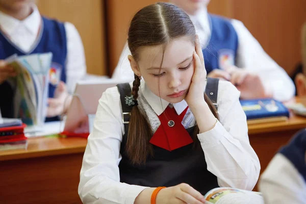 Leerlingen bij de receptie denken en beslissen de taak in de school. Primair onderwijs-, opleidings- en mensen-concept — Stockfoto