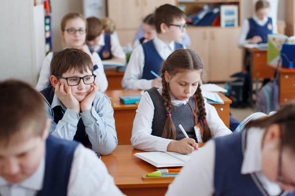 Schüler am Schreibtisch denken und entscheiden die Aufgabe in der Schule. prim — Stockfoto
