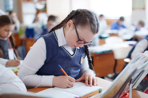 Schüler am Schreibtisch denken und entscheiden die Aufgabe in der Schule. prim — Stockfoto