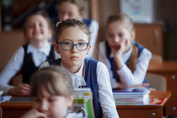 Pupils at the desk think and decide the task in the school. Prim — Stock Photo, Image