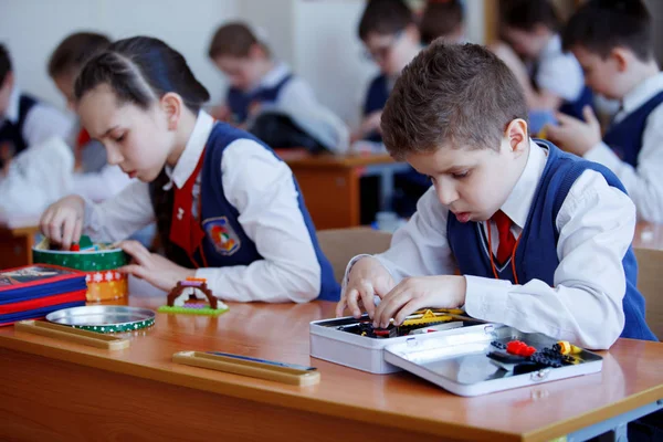 Dzieci w wieku szkolnym grać w budynku zestaw plastikowych klocków na lekcji w szkole podstawowej — Zdjęcie stockowe