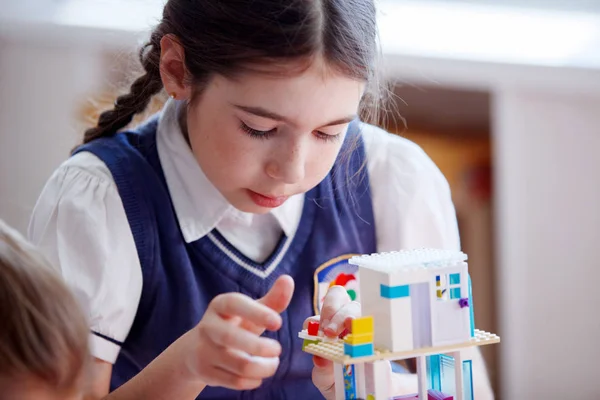 Les écoliers jouent dans des blocs de plastique de kit de construction lors d'une leçon à l'école primaire — Photo