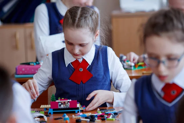 Iskolás gyerekek játszanak egy leckét, általános iskolai készlet műanyag építőelemei — Stock Fotó