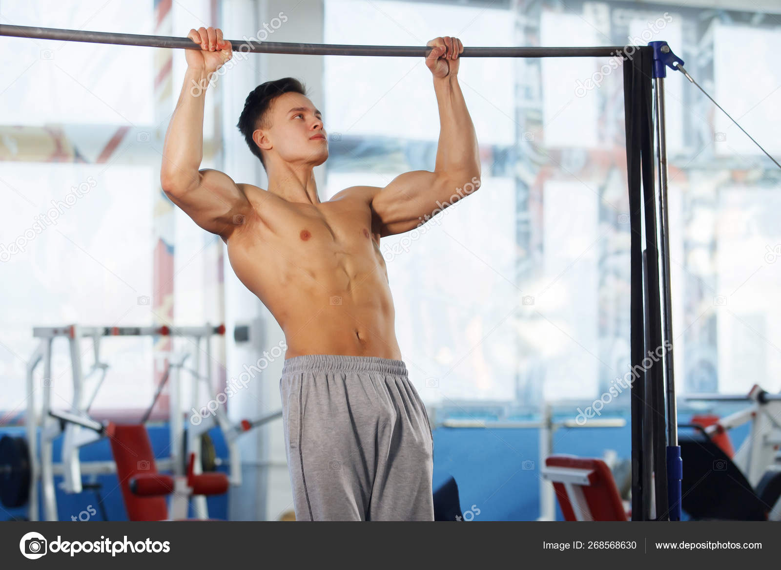 Man making exercises on crossbar. Stock Photo by ©vorobevaola 268568630