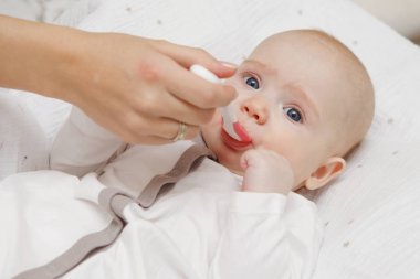 Bir kaşıkla yemek güzel güzel beş aylık kız bebek. Sağlıklı gıda. Anne bakım. Çocuk Bakımı. Yakın çekim.