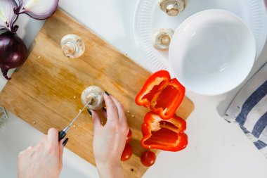 Kadın elleri mutfakta sebze kesiyor..