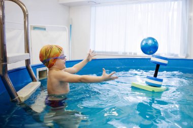 Sarı şapkalı çocuk ve gözlüklü çocuk merdivenlerde oturuyor. 