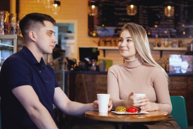 Bir kafede iki sevimli genç erkek ve kız.