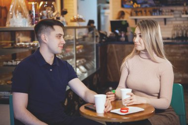 İki sevimli genç öğrenciler - erkek ve kız, bir kafede oturup.