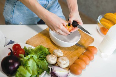 Genç ve güzel bir kadın omlet hazırlıyor..