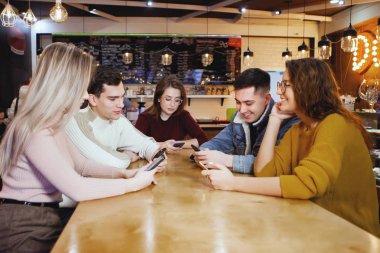 Bir kafede oturan beş genç yakışıklı öğrenci.