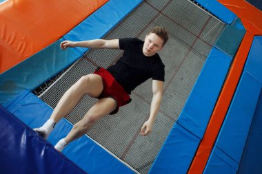 Bir trambolin üzerinde atlama genç adam.