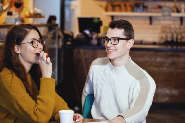 İki sevimli genç erkek ve bir kafede bir kız.