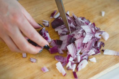 Kadın elleri bıçakla kesiyor.