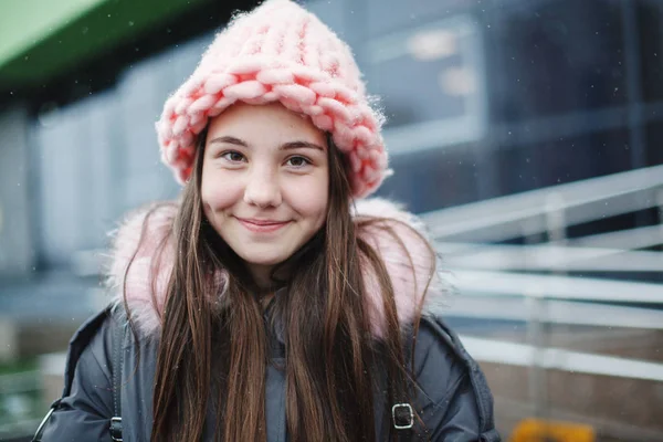 Açık havada gülümseyen genç genç kızın yakın portresi.