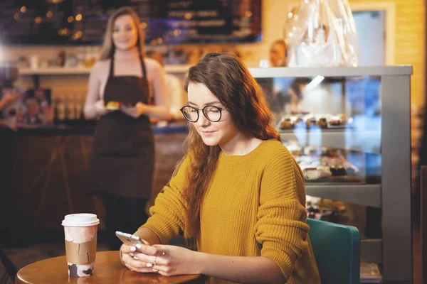 Joven mujer bonita y camarera en la cafetería . — Foto de Stock