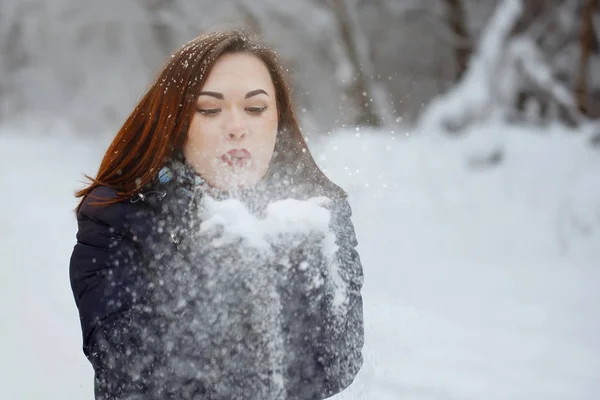 Ung, vacker kvinna i blå halsduk och jacka i en snöig skog — Stockfoto
