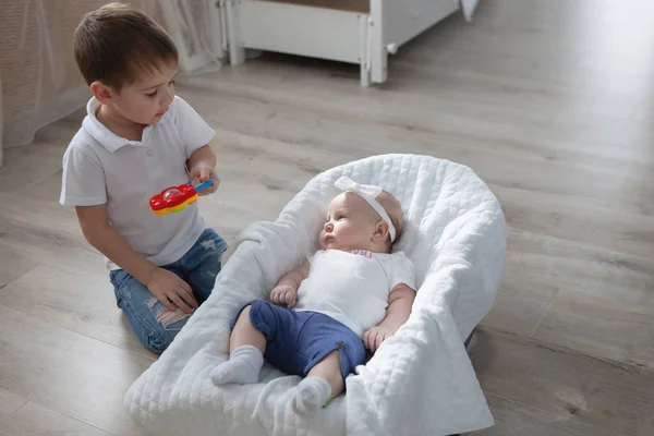 Chico juega con su hermana en una silla de ruedas . —  Fotos de Stock