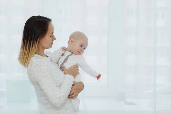 Ung Mamma Med Bebis Famnen Vid Fönstret — Stockfoto