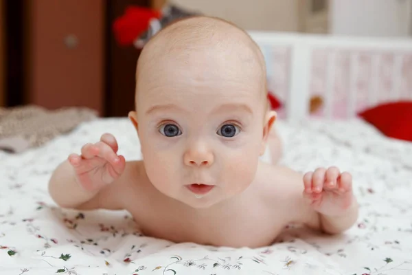 ヶ月の美しい青い目の赤ちゃん彼女の顔にさまざまな感情 彼女の胃の上に横たわる女の赤ちゃん 幼児の一見 妊産婦ケア クローズ アップ — ストック写真