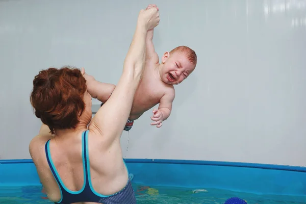 Madre con ejercicios de bebé en la piscina . —  Fotos de Stock