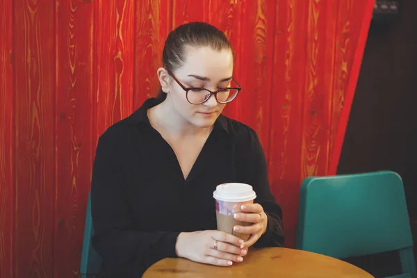 Bir kafede gözlüklü bir genç güzel kadın. — Stok fotoğraf