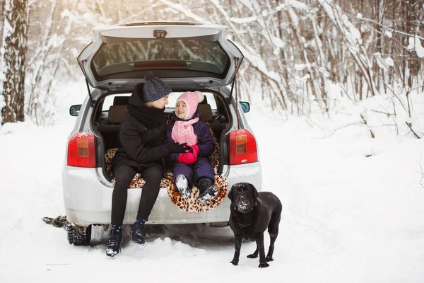 Chłopiec i dziewczynka siedzą z psem Retriever w bagażniku samochodu — Zdjęcie stockowe