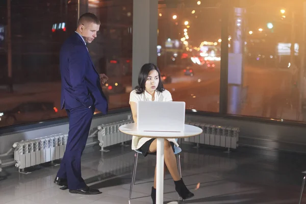 Betreiberin an einem Tisch mit Laptop und Geschäftsmann. — Stockfoto