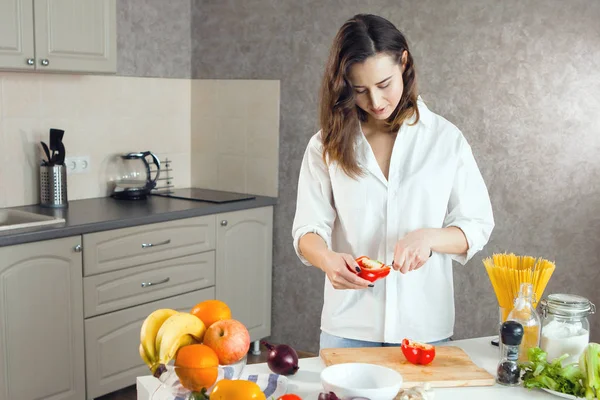 Woman cuts vegetables in the kitchen — Stock Photo, Image