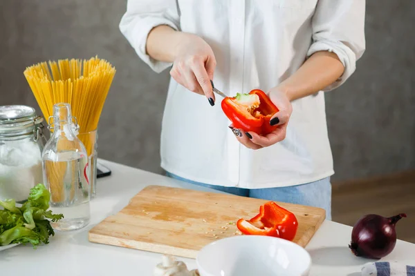 Kadın elleri mutfakta sebze kesiyor..