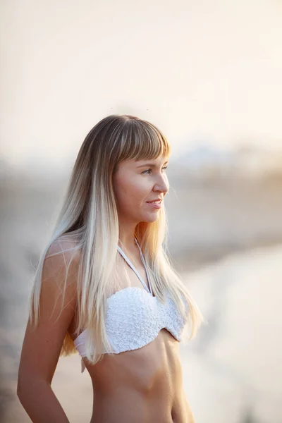 Gelukkige vrouw glimlachend en poseren op het strand. — Stockfoto