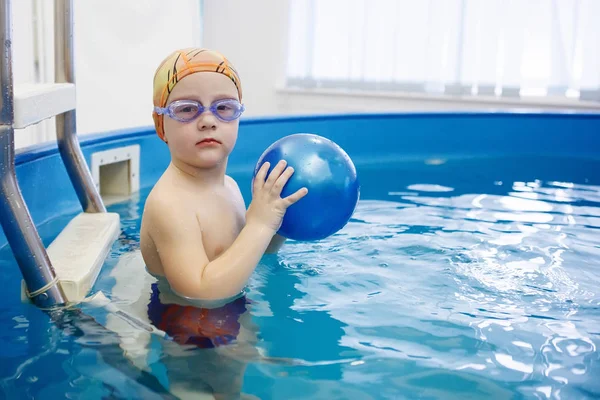 Sarı şapkalı çocuk ve gözlüklü çocuk merdivenlerde oturuyor. 