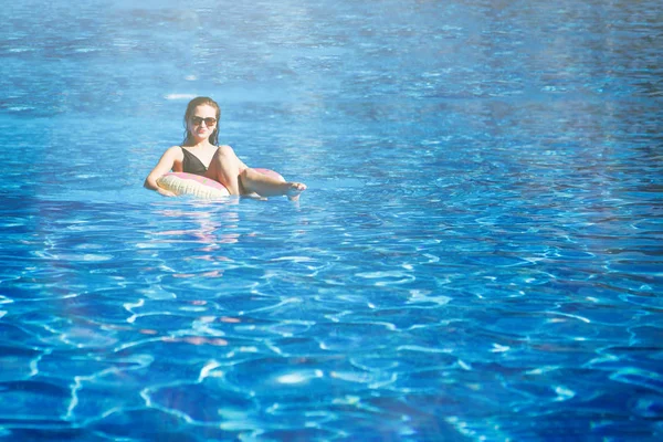 Młoda Ładna dziewczyna żagle na pływający pierścień w basenie z Clea — Zdjęcie stockowe