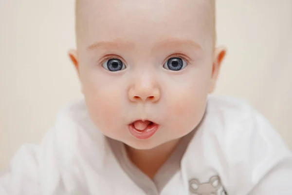 美丽的五个月蓝眼睛女婴躺在她的肚子上 表现出舌头 各种情绪和脸上的微笑 婴儿的样子 产妇护理 — 图库照片