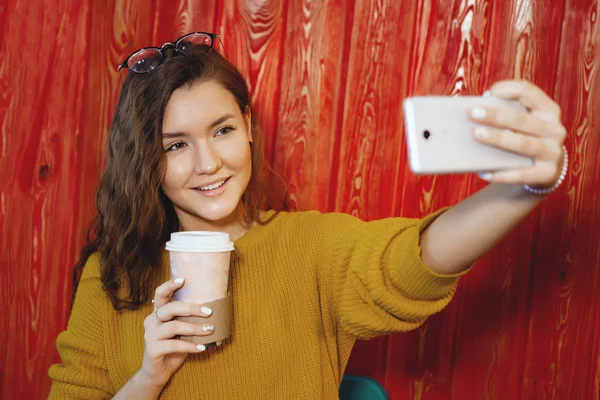 Portrait of beautiful young woman with phone in cafe. — Stock Photo, Image